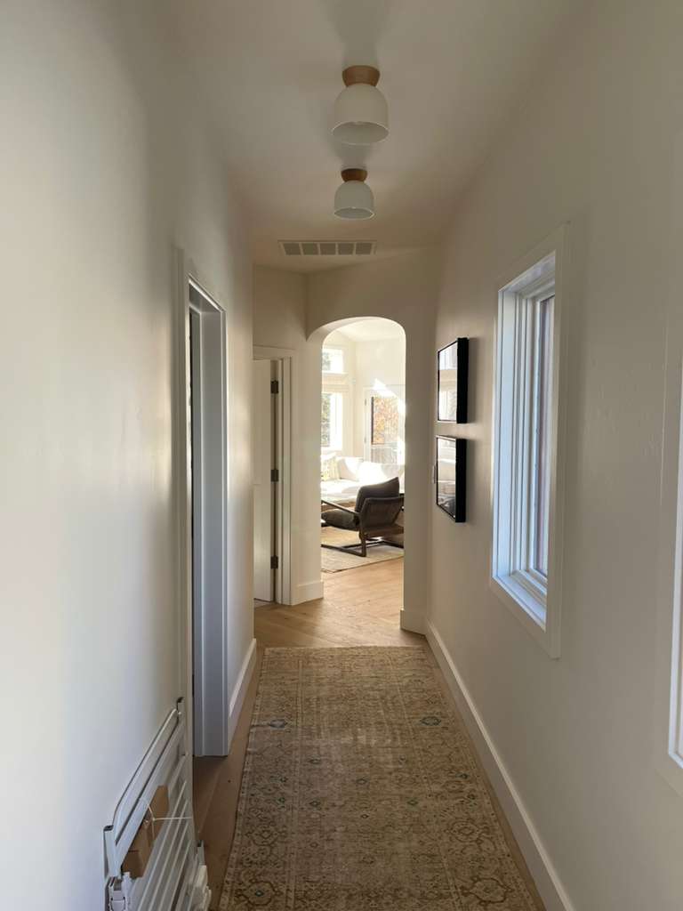 Bright hallway with arched doorway and warm white walls